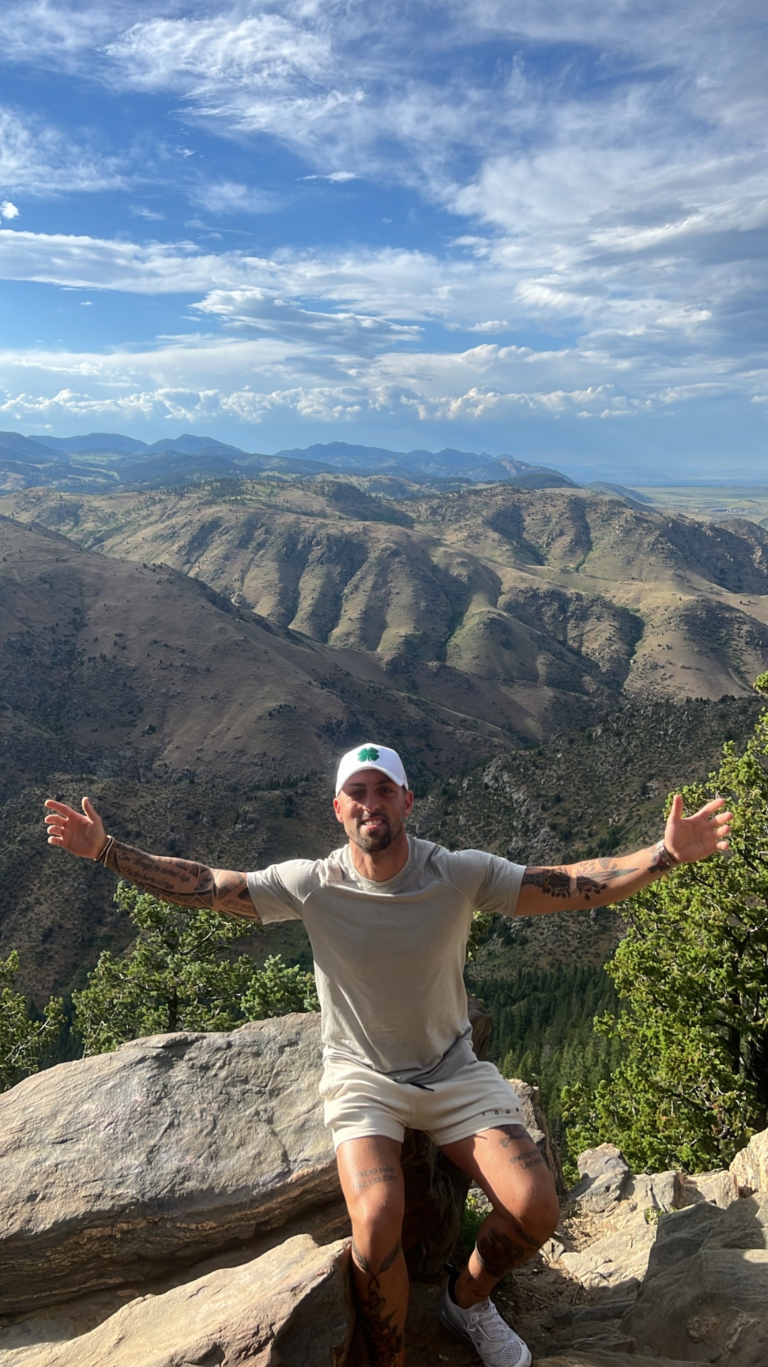 Dylan on a mountain summit, arms wide